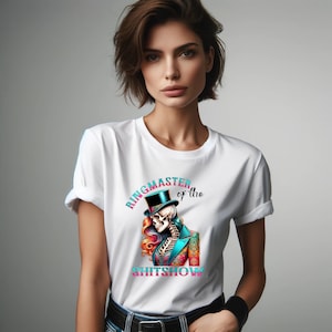 May include: White t-shirt featuring a graphic of a skeleton wearing a top hat and a tuxedo. The text "Ringmaster of the Shitshow" is printed on the shirt.