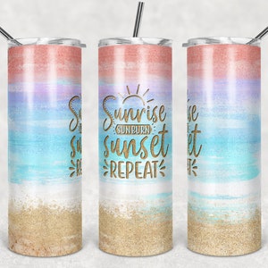 May include: A stainless steel tumbler with a lid and straw. The design features a watercolor-style gradient of coral, lavender, and blue, with a sandy beach effect at the bottom. Gold text reads "Sunrise Sunburn Sunset Repeat."