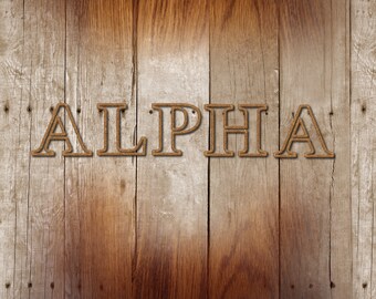 May include: The word "ALPHA" is spelled out in large, brown letters on a wooden background. The wood is a light brown color with darker brown streaks.