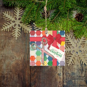 May include: A Christmas ornament featuring a red and white patchwork design with a pair of scissors and a red bow. The ornament has a tag that says "Merry Christmas 2021".