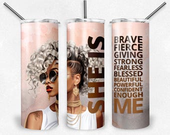May include: A set of three stainless steel insulated tumblers with a portrait of a woman with gray curly hair, sunglasses, and gold jewelry. The tumblers have the words "SHE IS" and "BRAVE, FIERCE, GIVING, STRONG, FEARLESS, BLESSED, BEAUTIFUL, POWERFUL, CONFIDENT, ENOUGH, ME."