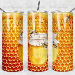 May include: A stainless steel tumbler with a honey-themed design. The design features a honeycomb pattern, dripping honey, and illustrations of bees. The tumbler includes a lid and a straw.