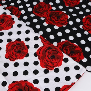 Op de afbeelding: Twee stukken stof met een bloemen- en polkadotpatroon. De ene stof is wit met zwarte stippen en rode rozen. De andere stof is zwart met witte stippen en rode rozen. De stoffen zijn gevouwen.