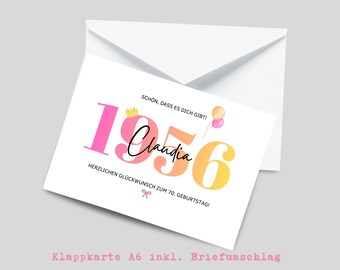 May include: A white greeting card with a matching envelope featuring the year 1956 in large pink, orange, and yellow gradient numbers. The name Claudia is written in black script, with a small gold crown, two balloons, and the text SCHÖN, DASS ES DICH GIBT! HERZLICHEN GLÜCKWUNSCH ZUM 70. GEBURTSTAG! and a pink bow icon.
