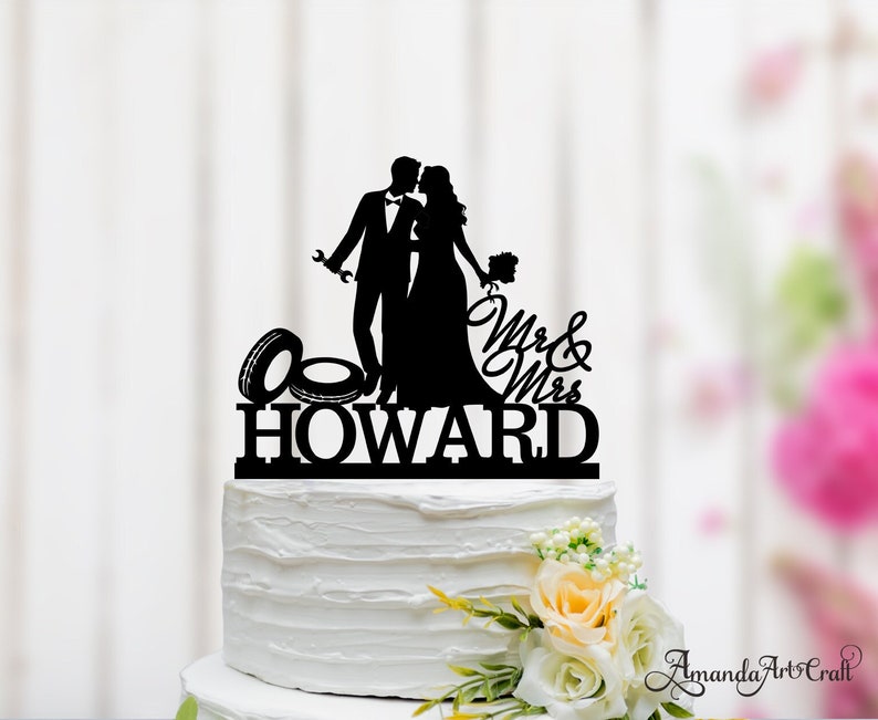 May include: Black silhouette cake topper of a bride and groom with a tire and the text "Mr. & Mrs. Howard"
