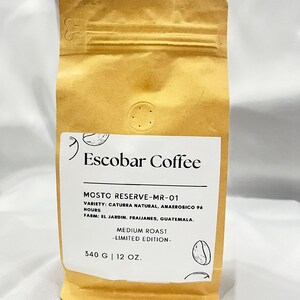 May include: A brown paper bag of Escobar Coffee. The label reads "MOSTO RESERVE-MR-01" and "MEDIUM ROAST -LIMITED EDITION-". The bag contains 12 oz (340 g) of coffee beans. The coffee is from El Jardin, Fraijanes, Guatemala.