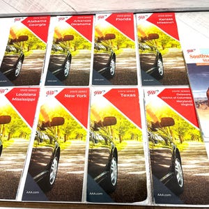 May include: A collection of AAA State Series travel maps, featuring states like Alabama, Georgia, Arkansas, Oklahoma, Florida, Kansas, Missouri, Louisiana, Mississippi, New York, Texas, and a Southwestern States map. Each map has a red and yellow design with a car image.