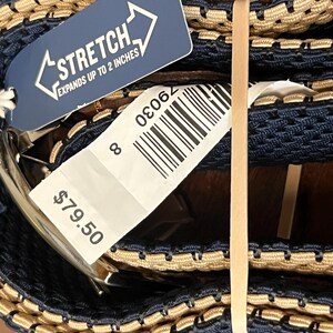 Puede incluir: Un cintur&oacute;n el&aacute;stico azul marino y beige con hebilla plateada. El cintur&oacute;n se extiende hasta 5 cm. Una etiqueta adjunta con la palabra "STRETCH" y el n&uacute;mero 8.