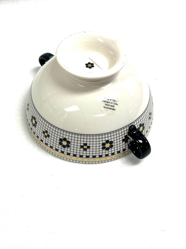 Pu&ograve; includere: Una tazza di ceramica bianca con manico nero e la scritta "But First, Coffee" in grassetto nero. La tazza &egrave; posta su uno sfondo sfocato, che suggerisce un'atmosfera accogliente.