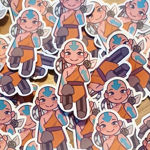 May include: A collection of stickers featuring a cartoon character with a bald head, blue arrow markings, and orange and brown clothing. The character has a friendly expression and is surrounded by other identical stickers.