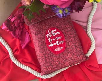 Red book sleeve with message: Open the door to a new adventure. Bookish one of a kind gift. Book lover.