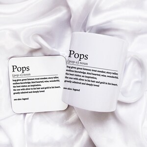 May include: White mug and coaster with the word "Pops" defined as "hug giver, great listener, treat sneaker, story teller, endless knowledge, kind hearted, wise, wonderful, the best visitor, an inspiration, the one with silver in his hair and gold in his heart, greatly admired and deeply loved. See also: legend."