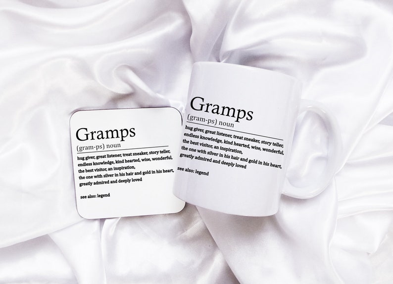 May include: White ceramic mug and coaster with black text that reads "Gramps (gram-ps) noun hug giver, great listener, treat sneaker, story teller, endless knowledge, kind hearted, wise, wonderful, the best visitor, an inspiration, the one with silver in his hair and gold in his heart, greatly admired and deeply loved see also: legend"
