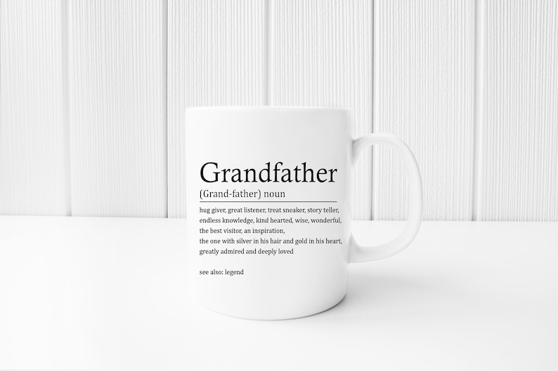 May include: White ceramic mug with a black graphic that reads "Grandfather (Grand-father) noun hug giver, great listener, treat sneaker, story teller, endless knowledge, kind hearted, wise, wonderful, the best visitor, an inspiration, the one with silver in his hair and gold in his heart, greatly admired and deeply loved see also: legend"