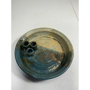 May include: A blue and white ceramic dish with three small holes for candles. The dish has a rustic, handmade look.