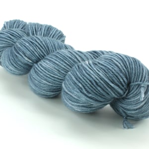 May include: A skein of blue yarn with white flecks. The yarn is soft and fluffy, and it is perfect for knitting or crocheting.