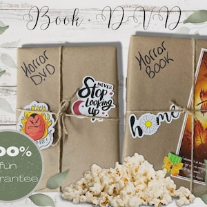 May include: Two rectangular items wrapped in brown paper, tied with twine. One is labeled Horror DVD with a sticker saying Never Stop Looking Up and a red character sticker. The other is labeled Horror Book with a home sticker and a leaf bookmark.