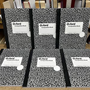May include: Six Oxford composition books with a classic black and white speckled marble pattern cover. Each notebook features a black spine and a white label on the front with the text Oxford Composition Book, 4x4 graph rule, 80 sheets, 9.75 x 7.5.