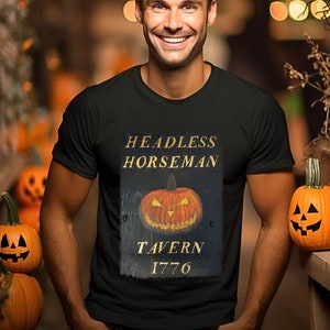 May include: A black t-shirt with a graphic of a vintage wooden sign that reads "Headless Horseman Tavern 1776". The sign features a carved jack-o'-lantern with a toothy grin.