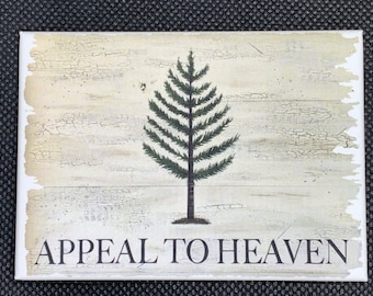 Puede incluir: Un letrero de madera de estilo vintage con un pino verde y el texto "APPEAL TO HEAVEN". El letrero tiene un aspecto desgastado y envejecido con un fondo blanco.