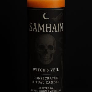 May include: Tall orange candle in a clear glass jar with a black label. The label features the word "SAMHAIN" above a skull graphic, with "WITCH'S VEIL" and "CONSECRATED RITUAL CANDLE" below. The candle is crafted by Venus Moon Emporium.