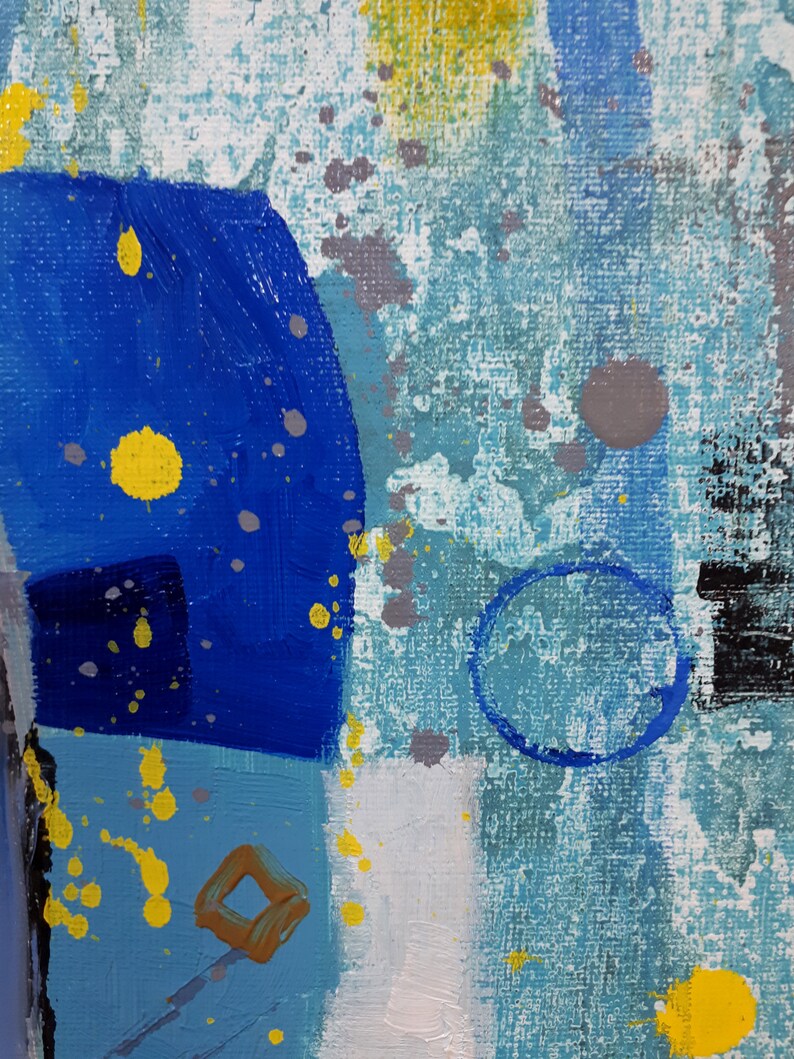 May include: Abstract painting with blue, yellow and grey paint splatters on a textured canvas. The painting features geometric shapes and a circular design.