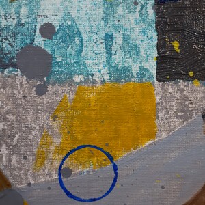 May include: Abstract painting with a blue circle, yellow, grey, and brown paint on a textured canvas.