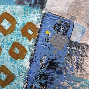 May include: Abstract painting with a blue, grey, and white background. The painting features a variety of shapes and textures, including squares, circles, and lines. The painting is done in a bold and expressive style.