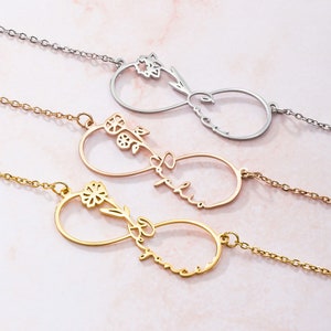 May include: Three infinity symbol necklaces with delicate floral accents and personalised names. The necklaces are in gold, rose gold, and silver.