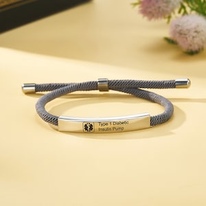 May include: Grey medical alert bracelet with a silver tag that reads "Type 1 Diabetic Insulin Pump" and a medical symbol.