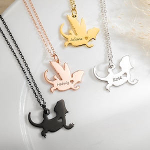 Peut inclure: Trois colliers en argent avec un pendentif en forme de silhouette de lézard. Chaque pendentif porte un nom gravé différent : Juliana, Hedwig et Rose.