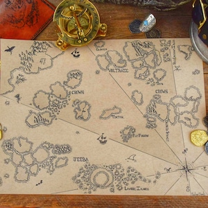 May include: A hand-drawn fantasy map with island illustrations, compass rose, and text labels. A brass compass, leather journal, and coins surround the map. The map is on a brown paper background.