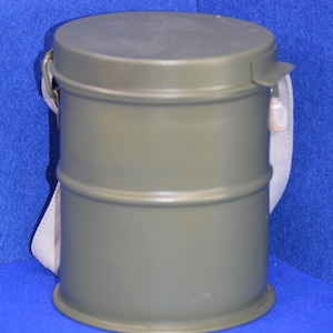 May include: An olive green metal container with a rounded top and bottom, and a cylindrical body. The container has a light-coloured strap attached to it. The container is likely used for storage or protection.