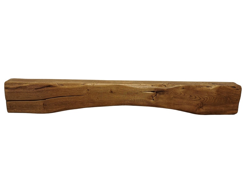 May include: A rustic wooden mantel shelf with a natural brown finish. The shelf has a slightly curved shape and shows signs of age and wear.