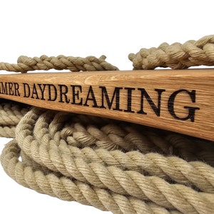 May include: A wooden swing set with thick rope and the words "SUMMER DAYDREAMING" engraved on the top.