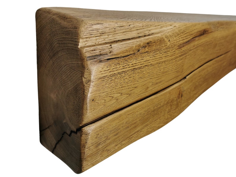 May include: A rustic, reclaimed wood mantel shelf with a natural, brown finish. The shelf has a unique, irregular shape and shows signs of age and wear.