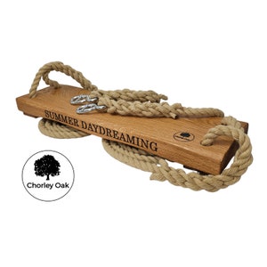 May include: A wooden swing set with rope and metal hooks. The swing is engraved with the words "Summer Daydreaming".