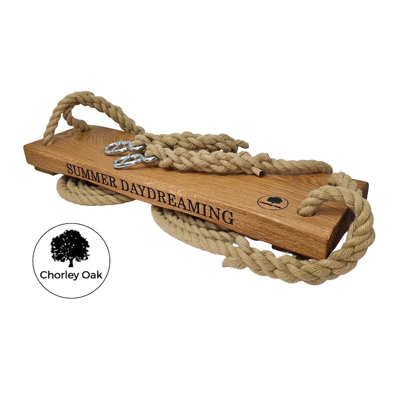 May include: A wooden swing set with rope and metal hooks. The swing is engraved with the words "Summer Daydreaming".
