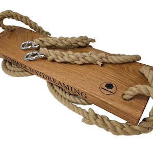 May include: A wooden swing set with natural rope and metal hooks. The swing is engraved with the text "Summer Daydreaming" and a logo.