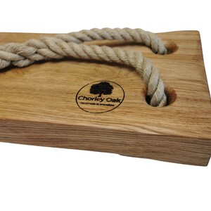 May include: A wooden swing seat with two rope loops and a logo that says "Chorley Oak Handmade in Lancashire".