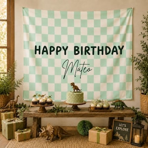 Peut inclure: Une grande toile de fond rectangulaire en tissu avec un motif à carreaux vert menthe clair et blanc. Le texte "HAPPY BIRTHDAY" est imprimé en lettres capitales vert foncé au-dessus du prénom "Mateo" en écriture cursive noire.