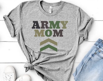 Könnte beinhalten: Ein graues T-Shirt mit dem Text "ARMY MOM" in schwarzen und grünen Buchstaben. Die Buchstaben sind übereinander gestapelt, wobei das Wort "MOM" etwas kleiner ist als das Wort "ARMY". Unter dem Text befinden sich drei grüne Chevron-Formen.