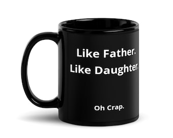 May include: Black ceramic coffee mug with white text that reads "Like Father. Like Daughter. Oh Crap."