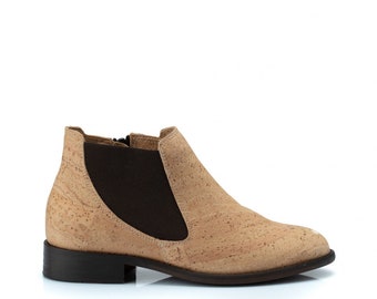 May include: Beige ankle boots made of cork with a brown elastic panel and a zipper on the side.