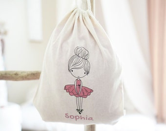 Op de afbeelding: Een witte trekkoordtas met een ballerina-illustratie en de naam "Sophia" gedrukt op de voorkant.
