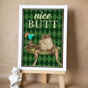 May include: A green and white poster featuring a frog perched on a lily pad, holding a blue cocktail. The poster reads "nice BUTT" in large yellow lettering.