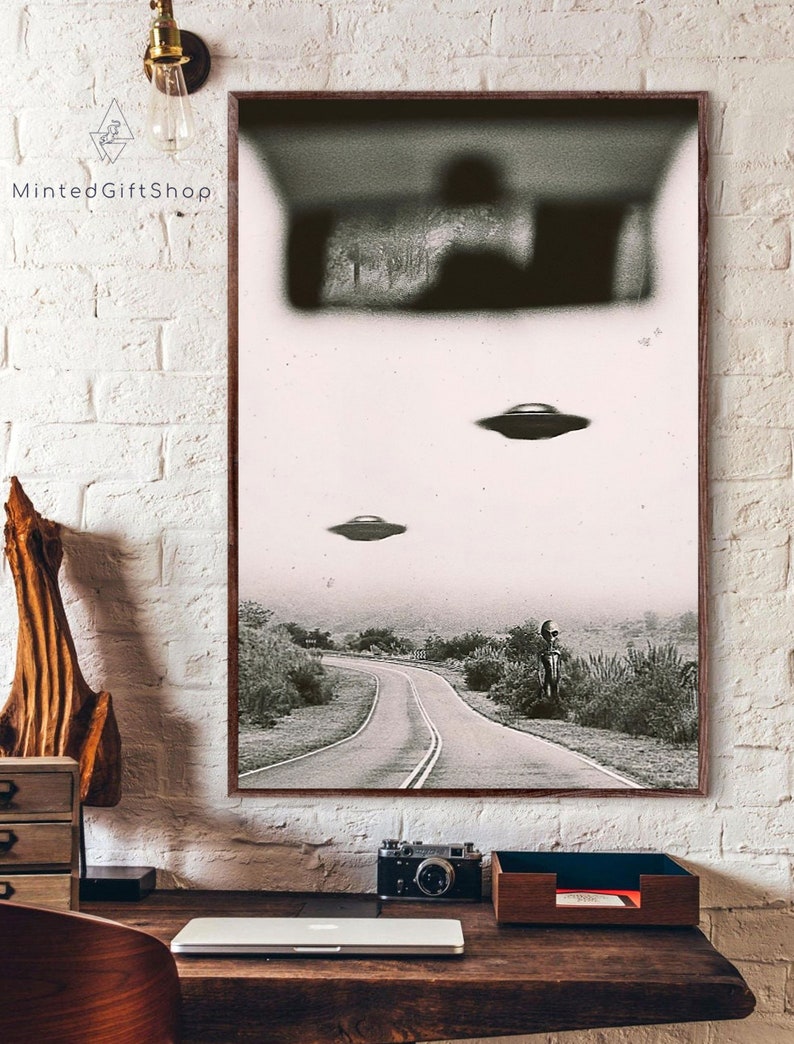 May include: A black and white photograph of a road with three flying saucers in the sky. The road is winding and there is a figure standing in the distance. The image is grainy and has a vintage feel.