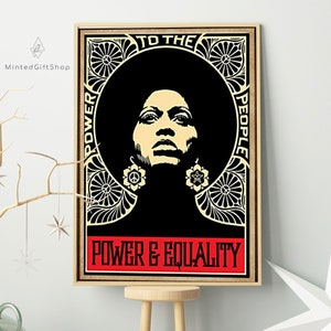 May include: A black and white poster featuring a woman with an afro wearing large earrings. The poster has a black background with a gold ornate border. The text on the poster reads "To The People" and "Power & Equality".