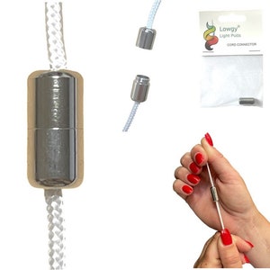 Puede incluir: Conector de cable plateado para un tirador de luz. El conector se muestra en tres posiciones diferentes: conectado a un cable blanco, desconectado del cable y sostenido por una mano. También se muestra el embalaje del conector, con la marca "Lowgy Light Pulls" y el texto "Cord Connector".