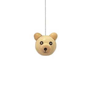 May include: A wooden bear head light pull with black eyes and a brown nose. The bear head is light brown and has a string attached to the top.